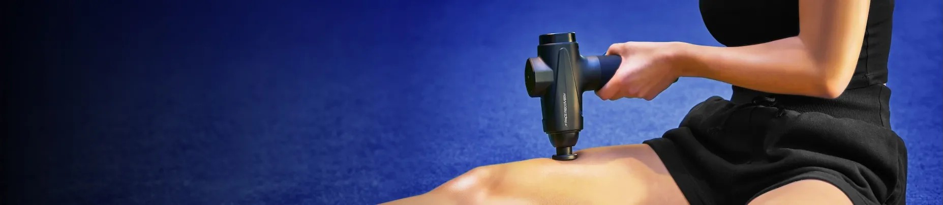 Sporter gebruikt de Pace Recovery Pulse 1 massage gun op het bovenbeen voor effectieve spierherstelmassage.