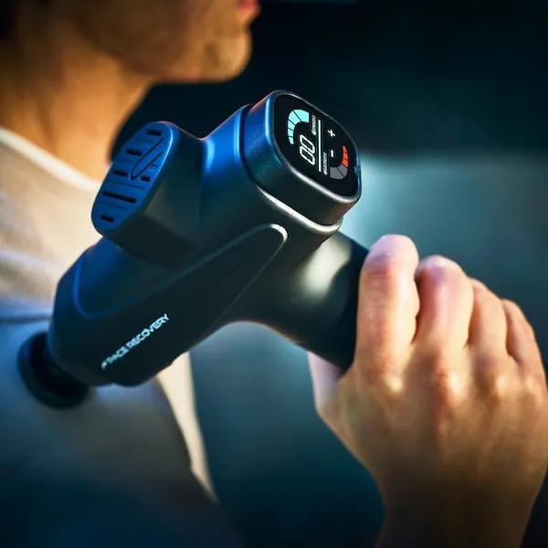 Sporter gebruikt de Pace Recovery Pulse 1 massage gun op de schouder voor spierontspanning.