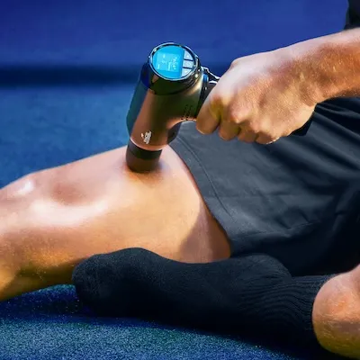 Atleet masseert zijn bovenbeen met de Pace Recovery Elite 1 massage gun voor sneller herstel.